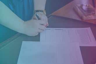 woman signing a document on a table