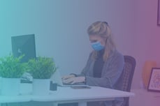 woman with a mask on working at her desk